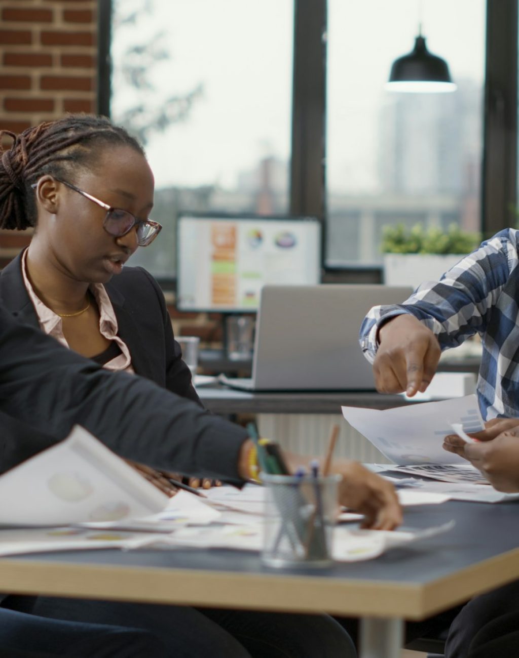 Team of african american businesspeople analyzing charts documents